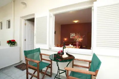 a patio with a table and chairs and a window at Agapi Studios in Kato Daratso