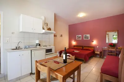 a kitchen and a living room with a bed and a table at Agapi Studios in Kato Daratso