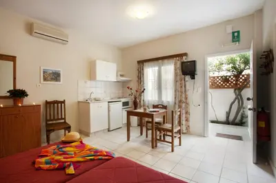 a kitchen and living room with a bed and a table at Agapi Studios in Kato Daratso