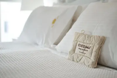 a white bed with a brown pillow on it at Casa Regina Luxury House in Chania Town