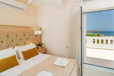 a bedroom with a bed with a view of the ocean at Villa Aretousa 1 in Agia Marina Nea Kydonias