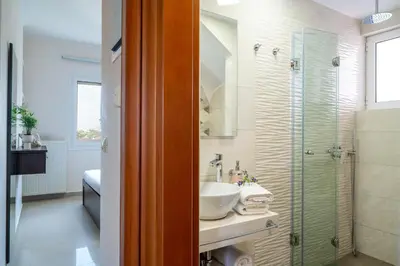 a bathroom with a sink and a shower at Villa Aretousa 1 in Agia Marina Nea Kydonias