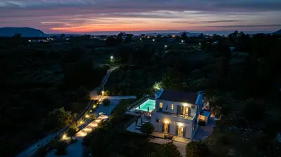 an aerial view of a house with a swimming pool at night at Villa di Lusso Agave con Piscina Privata Riscaldata e Jacuzzi in Litsárdha