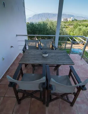 a wooden table and chairs on a balcony at Ktima Nikolaos in Arónion