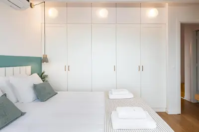 a white bedroom with a bed with white cabinets at Happy Villa in Kato Galatas