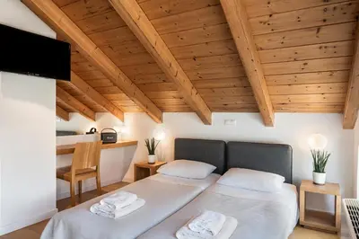 two beds in a room with wooden ceilings at Happy Villa in Kato Galatas