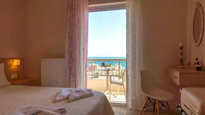 a bedroom with a bed and a view of a balcony at Vakakis-ME Apartments in Palaiochóra