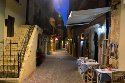 an alley with tables and chairs on a street at Elia Dorotheou in Chania Town