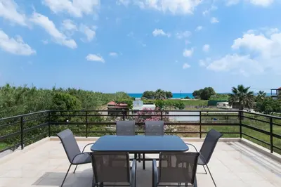 a patio with a table and chairs on a balcony at Sirens House in Tavronitis