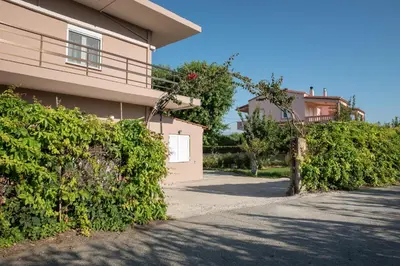 a house with a gate and bushes next to a driveway at Sirens House in Tavronitis