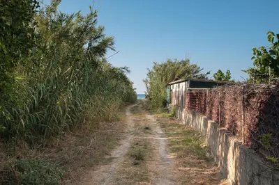 an old dirt road next to a fence at Sirens House in Tavronitis