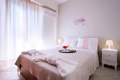 a white bedroom with a bed with a tray of flowers on it at Domus Creta in Kato Daratso