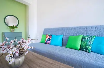 a blue couch with colorful pillows in a living room at Domus Creta in Kato Daratso