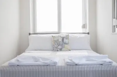 a white bed with two white towels on it at Domus Creta in Kato Daratso