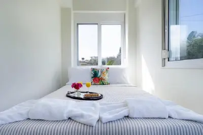 a bed with a tray of food and a window at Domus Creta in Kato Daratso