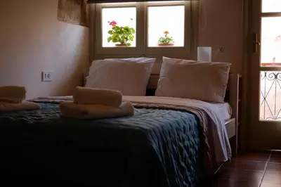 a bed with two windows and two towels on it at Fivos Pension in Chania Town
