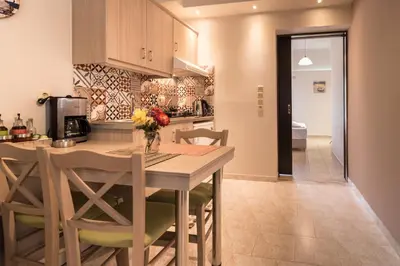 a kitchen with a wooden table and chairs in a room at Grameno Apartments in Kountoura Selino