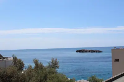 a view of the ocean with a rock in the water at John Akroyiali in Loutro