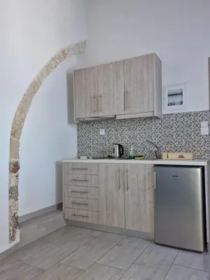 a kitchen with wooden cabinets and an archway at John Akroyiali in Loutro