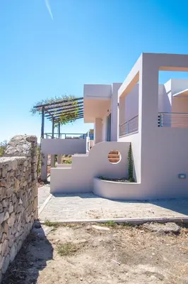 a white house with a staircase and a wall at Villa-Palaiochora in Palaiochóra