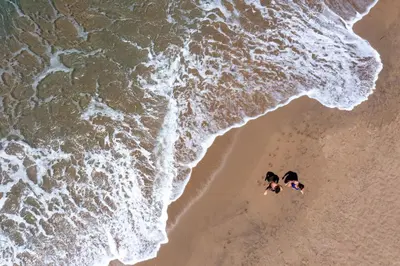 an overhead view of two people swimming on the beach at Blue Horizon in Palaiochóra