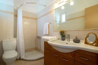 a bathroom with a sink and a toilet and a shower at Villa Dimokratia in Kolymvari