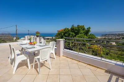 a patio with a table and chairs on a balcony at Villa Anatoli in Stalos