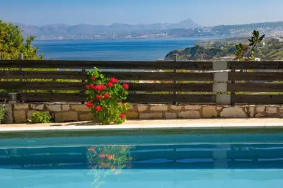 a fence with flowers next to a swimming pool at Villa Anatoli in Stalos