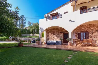 a house with a patio and a yard at Alia Stone Villa-Ideal for families-Heated pool in Nohia