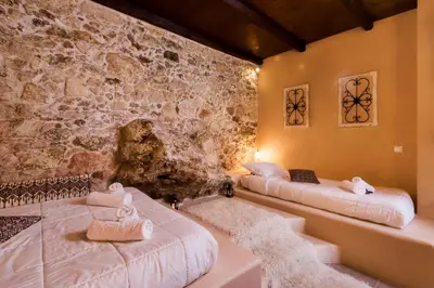 two beds in a room with a stone wall at Alia Stone Villa-Ideal for families-Heated pool in Nohia