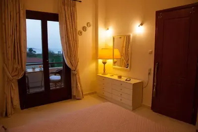 a bedroom with a dresser and a mirror and a window at Villa Allegra in Korfalónas