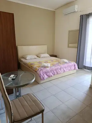 a bedroom with a bed and a table and a chair at Kleri Beloni Rooms in Chania Town