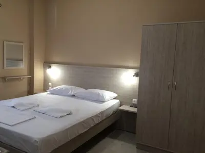 a bedroom with a large bed with white sheets and pillows at Kleri Beloni Rooms in Chania Town