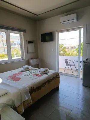 a bedroom with a large bed and a balcony at Kleri Beloni Rooms in Chania Town