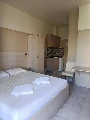 a bedroom with a large bed with white sheets at Kleri Beloni Rooms in Chania Town