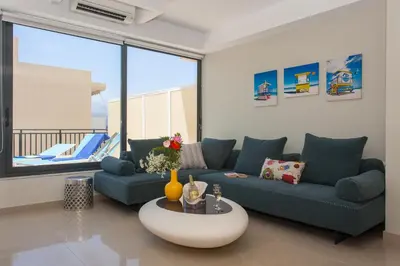 a living room with a blue couch and a table at Stefan's City Loft in Chania Town