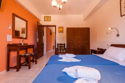 a bedroom with two beds with blue sheets and a desk at Poco Loco Bed & Breakfast in Chania Town