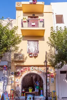 a yellow building with a balcony and a patio at Poco Loco Bed & Breakfast in Chania Town