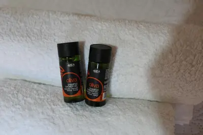 two bottles of shampoo sitting on top of towels at My Rooms in Chania Town