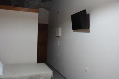 a bedroom with two beds and a tv on the wall at My Rooms in Chania Town
