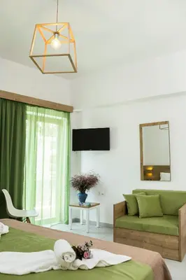 a bedroom with a green bed and a couch at Castell Hotel in Kissamos