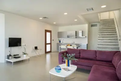 a living room with a purple couch and a kitchen at Blue Sea Luxury Villa in Maleme