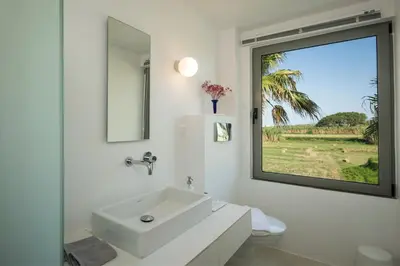 a white bathroom with a sink and a window at Blue Sea Luxury Villa in Maleme