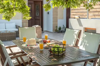 a wooden table with a plate of food and orange juice at Villa Christini in Kissamos