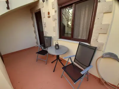 a small table and chairs in a room with a window at Nikos Studio in Kalyves