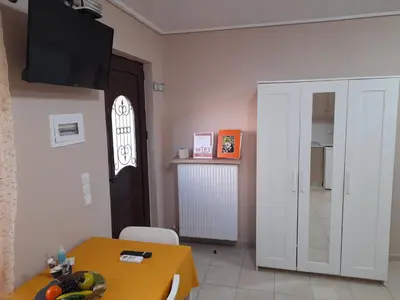 a dining room with a table and a television on the wall at Nikos Studio in Kalyves