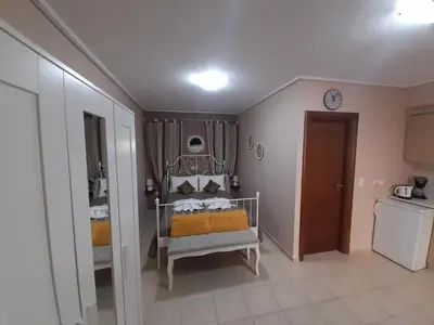 a bedroom with a bed and a clock on the wall at Nikos Studio in Kalyves