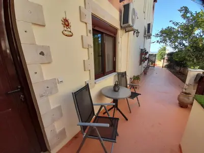 a patio with a table and chairs on the side of a building at Nikos Studio in Kalyves