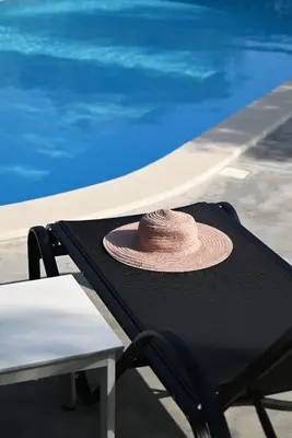a hat sitting on a table next to a swimming pool at Villa Felenia in Vryses