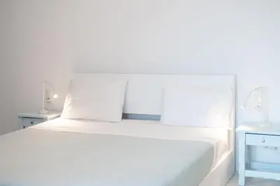 a white bed with white sheets and pillows at Elia in Kavoúsion